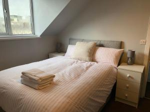 a bedroom with a bed with two pillows and a bag on it at Baron Apartment B in Ballymena