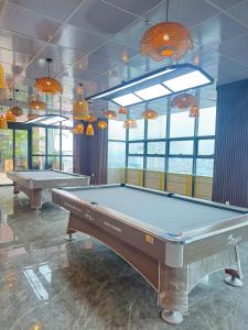two pool tables in a room with windows at The Sun Backpacker Hostel in Ninh Binh