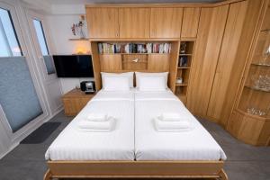 a bedroom with a large white bed with wooden cabinets at Wiking, App 019 in Westerland