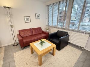a living room with a couch and a chair and a table at Wiking, App 019 in Westerland
