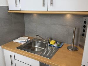 a kitchen counter with a sink and white cabinets at Wiking, App 019 in Westerland +13 photos