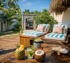 a patio with two couches and a table with fruit at The White Key Luxury Villas in Gili Trawangan
