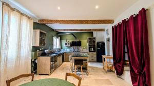 a large kitchen with red curtains in a room at Caractère de Beaumes in Beaumes-de-Venise