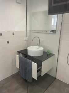 a bathroom with a sink and a mirror at Ferienhaus Wehretal - auf separatem Grundstück in Langenhain +13 photos