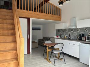 a kitchen and living room with a table and a counter at Le Phare in La Teste-de-Buch