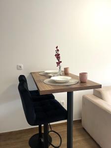 a wooden table with a vase of flowers on it at Studio Vila Alto in Vrbas