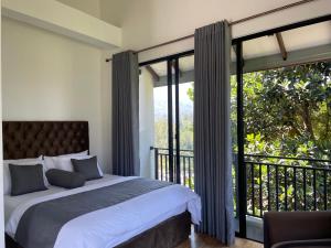 a bedroom with a bed and a large window at Lipton View Inn near Ella & Haputhale in Bandarawela