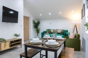 a living room with a table and a couch at The Knutsford loft in Knutsford