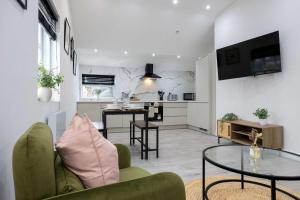 a living room with a table and a kitchen at The Knutsford loft in Knutsford +24 photos
