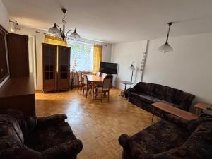 a living room with a couch and a dining room at House with garden For 8 people in Suwałki
