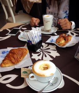 a table with plates of food and coffee and croissants at La Cycas in Trabia