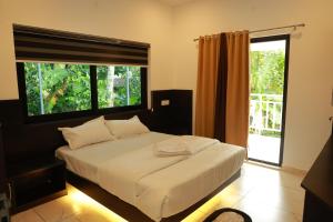 a bedroom with a large bed with a large window at Trinity Homestay Munnar in Anachal