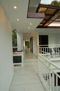a hallway of a house with a white staircase at Trinity Homestay Munnar in Anachal