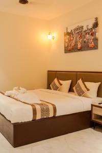 a bedroom with two beds and a painting on the wall at The Hue House in Sibsāgar