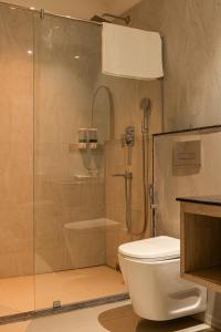 a bathroom with a shower and a toilet at The Hue House in Sibsāgar +6 photos