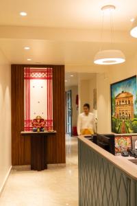 a man standing at the reception desk of a hospital at The Hue House in Sibsāgar
