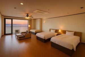 a hotel room with two beds and a balcony at 館山 New WestPeninsula Hotel ニューウエストペニンシュラホテル in Tateyama +48 photos