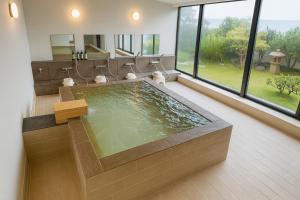 a large bathroom with a jacuzzi tub at 館山 New WestPeninsula Hotel ニューウエストペニンシュラホテル in Tateyama