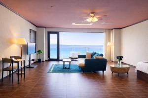 a living room with a view of the ocean at 館山 New WestPeninsula Hotel ニューウエストペニンシュラホテル in Tateyama