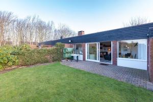 a brick house with a patio and a yard at Bungalow-Finlandia in Westerland