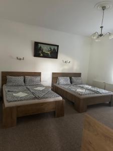 two beds sitting next to each other in a room at Viktor Apartmanház in Zamárdi