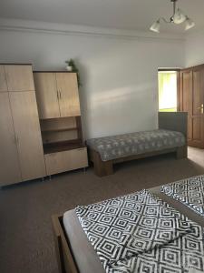 a room with two beds and a bench and cabinets at Viktor Apartmanház in Zamárdi +20 photos
