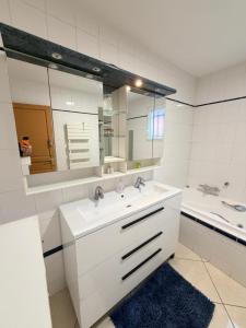 a white bathroom with a sink and a mirror at La Julia Chambre meublée près de Paris in Corbeil-Essonnes