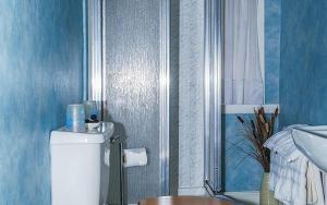 a blue bathroom with a toilet and a sink at Hamilton House Guest House in Oban