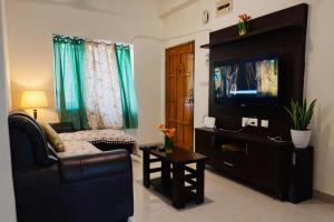 a living room with a couch and a flat screen tv at Deccan Homes Kondapur in Hyderabad