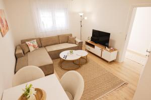 a living room with a couch and a tv at Apartmani Otium in Mostar