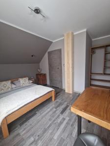 a bedroom with a bed and a wooden floor at Trzy Żywioły - Bieszczady in Wetlina