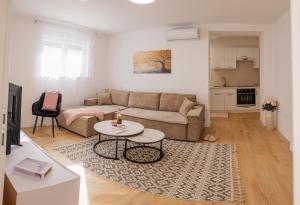 a living room with a couch and a table at Apartmani Otium in Mostar