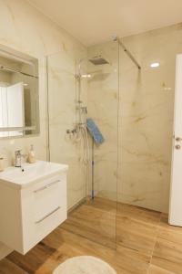 a bathroom with a sink and a glass shower at Apartmani Otium in Mostar +67 photos