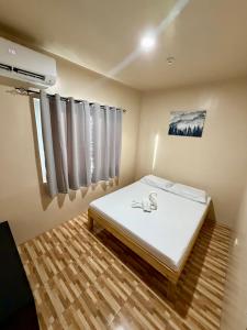 a bedroom with a white bed and a window at Siquijor Travellers Inn in Siquijor +8 photos