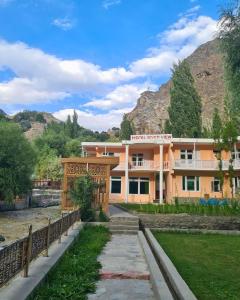 a building next to a river with mountains in the background at River View Hotel Shigar in Shigar