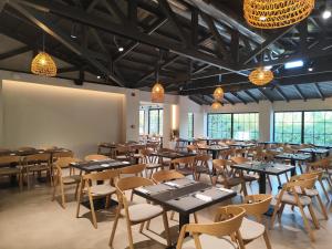 a dining room with tables and chairs and lights at NOBILIS CORFU Hotel in Acharavi