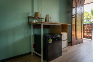 a kitchen with a black refrigerator under a table at The Nap Koh Yao Yai in Ban Nai Wat