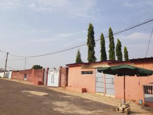 a building with a green umbrella next to a street at Résidence BEDEL in Yamoussoukro