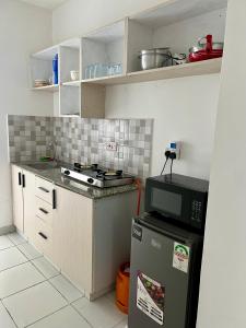 a small kitchen with a stove and a microwave at Leona Homes in Mombasa