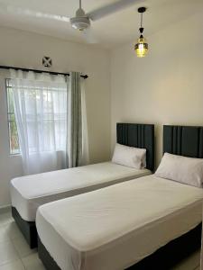 two beds sitting next to each other in a bedroom at Leona Homes in Mombasa