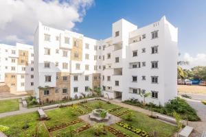 an apartment building with a garden in front of it at Leona Homes in Mombasa