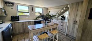 a kitchen with a counter with a table and chairs at The Gables in Grotto Bay +19 photos