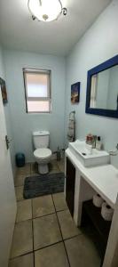 a bathroom with a white sink and a toilet at The Gables in Grotto Bay