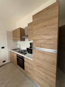 a kitchen with wooden cabinets and a stove at La Dimora del Lago d'Iseo in Sarnico