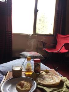 a table with a plate of food on a table at Durrani Lodges - Islamabad G11 in Islamabad