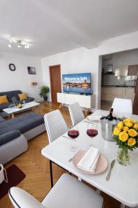 a living room with a white table with glasses of wine at Diocles Place in Split