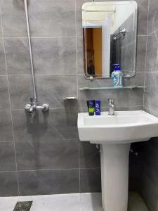 a bathroom with a sink and a mirror at Durrani Lodges - Islamabad G11 in Islamabad