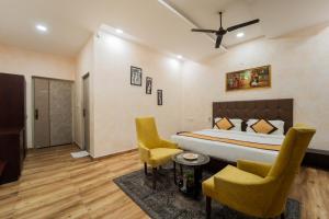 a bedroom with a bed and two chairs at Thar Exotica Hotel & Resort Bikaner in Bikaner