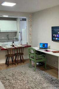 a kitchen with a table with a laptop computer on it at Aconchego in Maringá