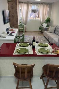 a living room with a table with plates and wine glasses at Aconchego in Maringá